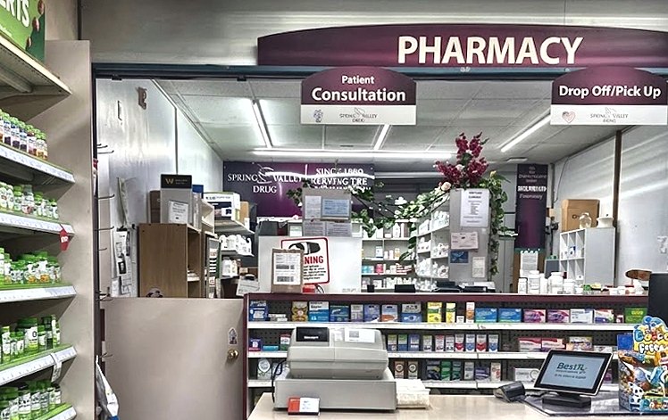 Inside Spring Valley Drug Pharmacy: the pharmacy counter with patient consultation and drop-off/pick-up windows.